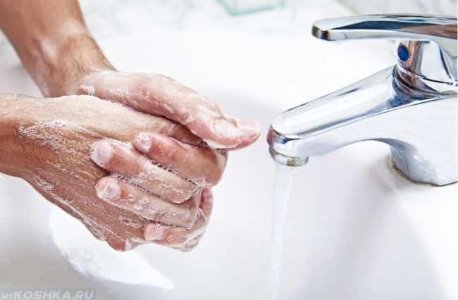 Мытьё рук под краном над раковиной с мылом